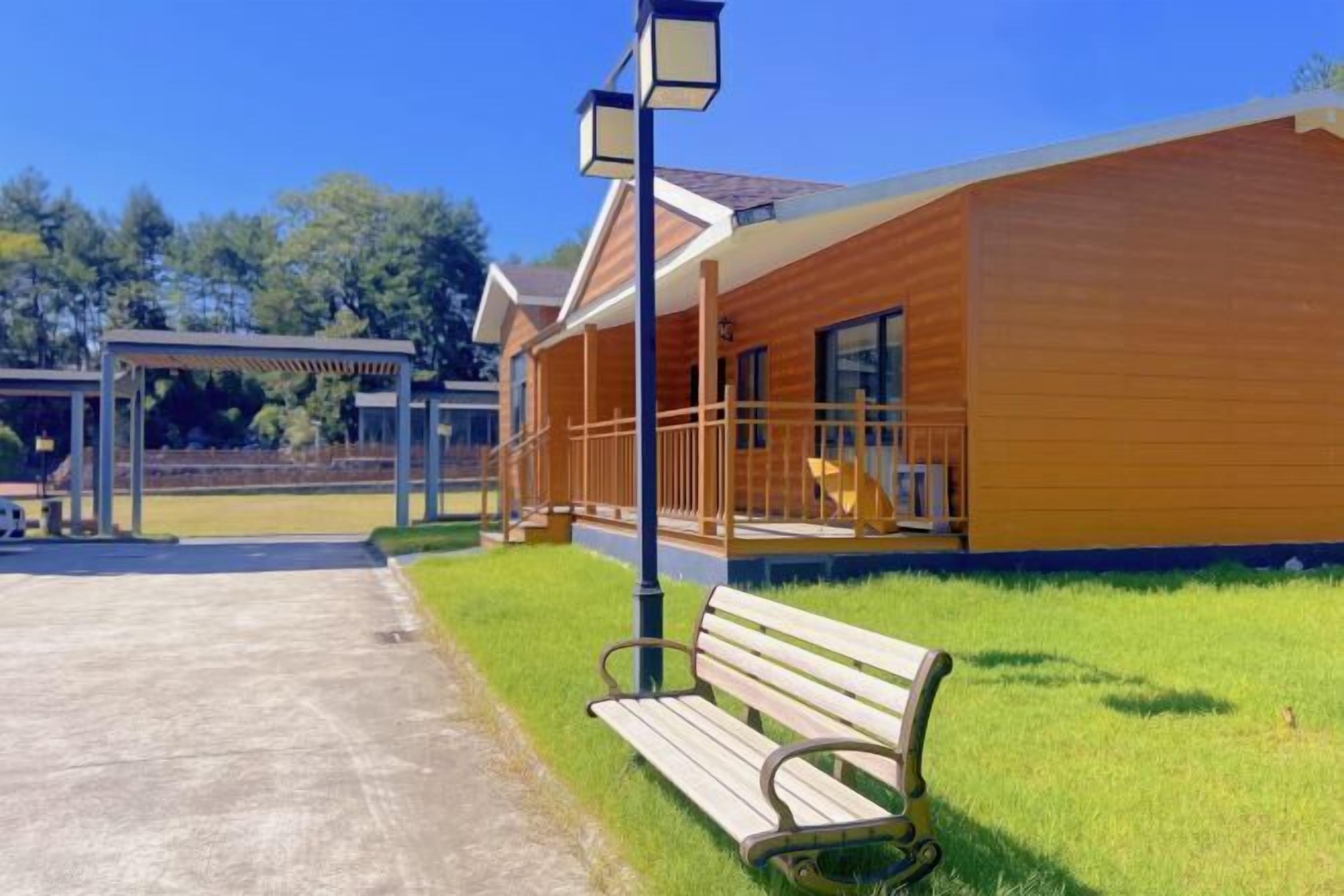 A modern building with a wooden exterior, a covered porch, and a bench.