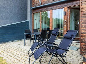 A patio with a table and four lounge chairs.
