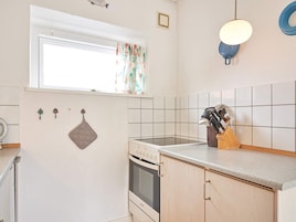 A kitchen with a window, a stove, and a countertop with kitchen utensils.