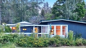 A modern cabin-style building with large windows and a porch area.