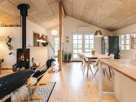 A spacious living area with a fireplace, wooden furniture, and a view through large windows.