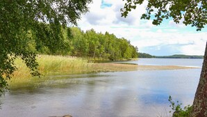 A calm lake surrounded by dense forest. - 4 Star Holiday Home in Nykvarn (Nykvarn)