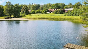 A calm lake with a wooden dock extending into the water. - 4 Star Holiday Home in Nykvarn (Nykvarn)