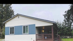 Een gelijkvloers huis met een veranda, een klein terras en een omheinde tuin.