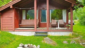 A wooden cabin with a porch, two seating areas, and a small table. - 6 Person Holiday Home in Olden (Stryn)