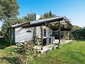 A house with a covered patio area, a small deck, and a garden.