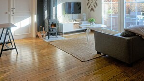 A cozy living room with a wood-burning stove, a flat-screen TV, and a comfortable seating area. - 7 Person Holiday Home in Solvesborg-by Traum (Sölvesborg)