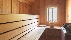 Un interior de madera con un banco, una ventana y una zona de sauna.