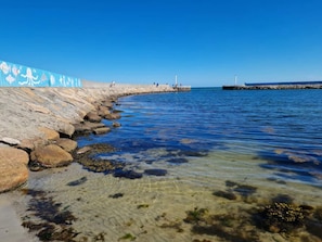 A coastal walkway with clear water, rocks, and a pier. - 6 Person Holiday Home in Hadsund (Hadsund)