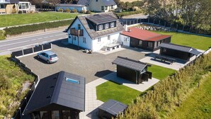 A residential property with a large house, a separate garage, and a small building with a red roof. - 10 Person Holiday Home in Roslev (Roslev)