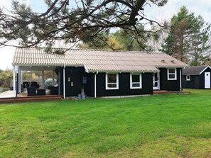 Une maison de plain-pied dotée d’un patio couvert, d’un petit garage attenant et d’une pelouse bien entretenue.