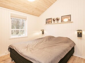 Une chambre à coucher avec un lit, une fenêtre et des lampes fixées au mur.