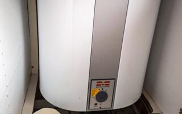 A large cylindrical water heater with a control panel.