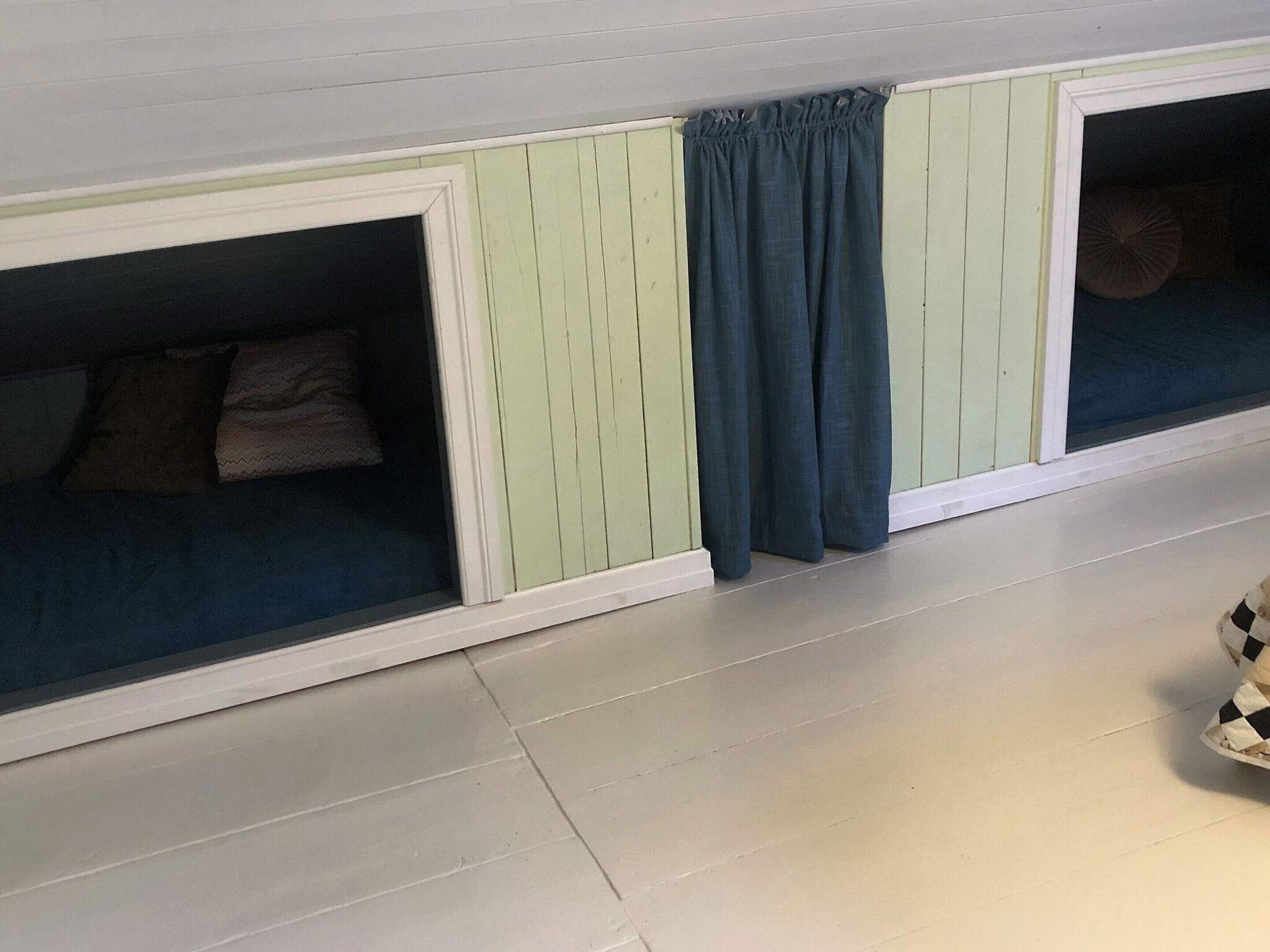 A room with a window, a curtain, and a checkered floor.