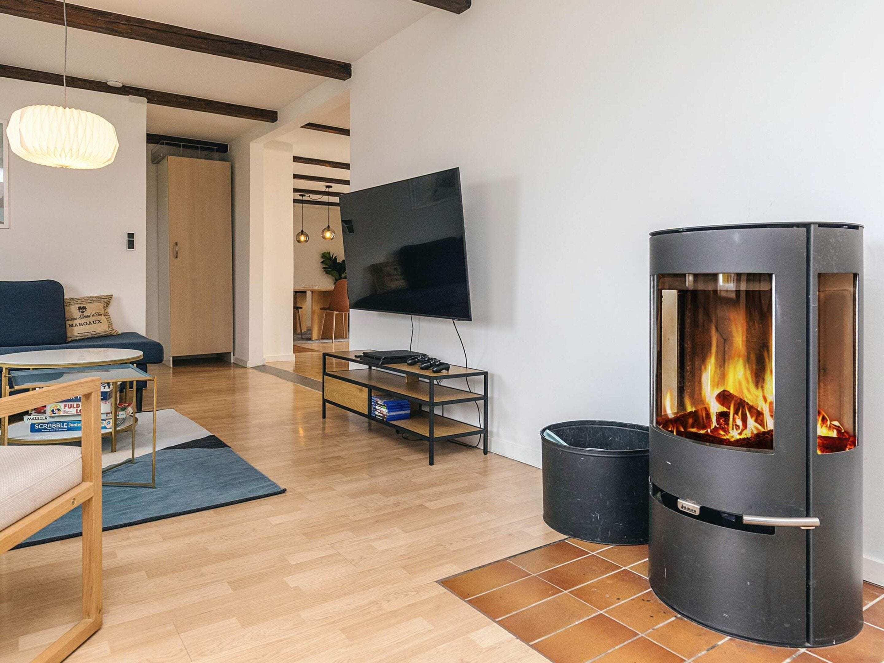 A modern living room with a fireplace, a sofa, a TV, and a coffee table.
