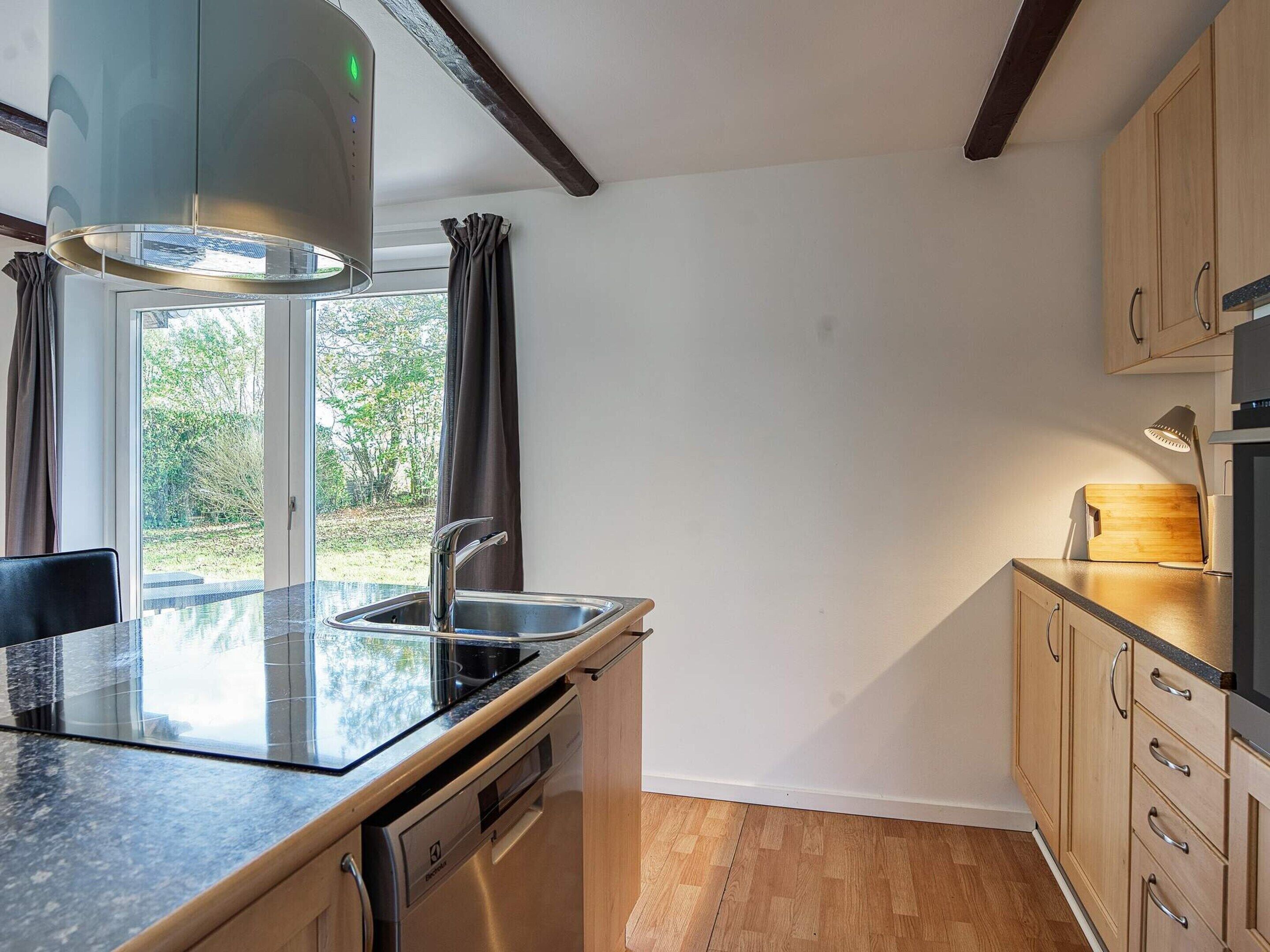 A modern kitchen with a built-in dishwasher, a sink, and a stove.