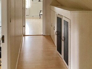 A hallway with a wooden floor leading to a room with a white door and a black-framed window. - 8 Person Holiday Home in Sakskobing (Sakskobing)