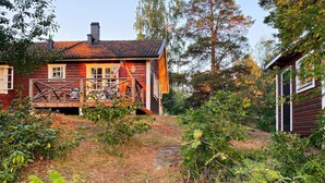 A wooden cabin with a balcony, surrounded by dense greenery and trees. - 4 Person Holiday Home in Horn (Horn)