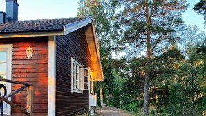 A wooden cabin with a porch and a stone pathway leading to it. - 4 Person Holiday Home in Horn (Horn)
