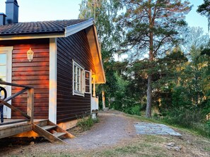 A wooden cabin with a porch and a stone pathway leading to it. - 4 Person Holiday Home in Horn (Horn)