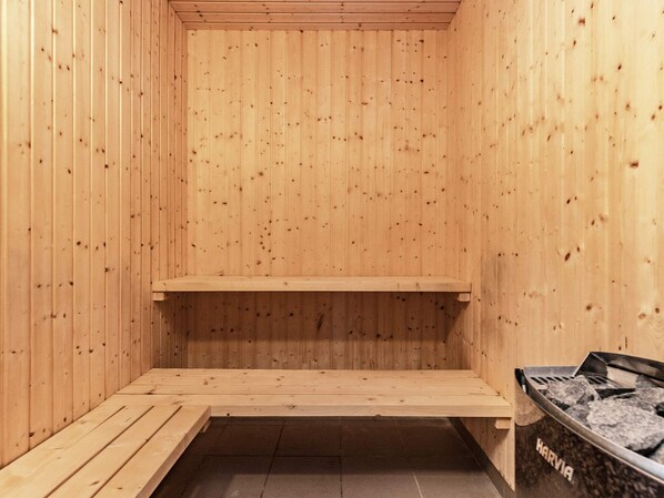 A sauna with wooden walls and a bench.