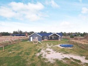 A modern house with a large patio, a small play area, and a trampoline. - 5 Star Holiday Home in Jerup (Jerup)