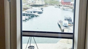 A view of a marina with boats docked, a clear sky, and buildings in the background. - 6 Person Holiday Home in Hernar (Oygarden)