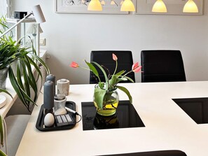 A table with a vase of flowers, a salt and pepper shaker set, and a black tray with a white object. - 4 Star Holiday Home in Varmdo (Värmdö)