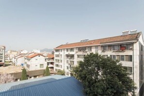 Un edificio residencial de varios pisos con balcones, techo plano y cielo despejado.