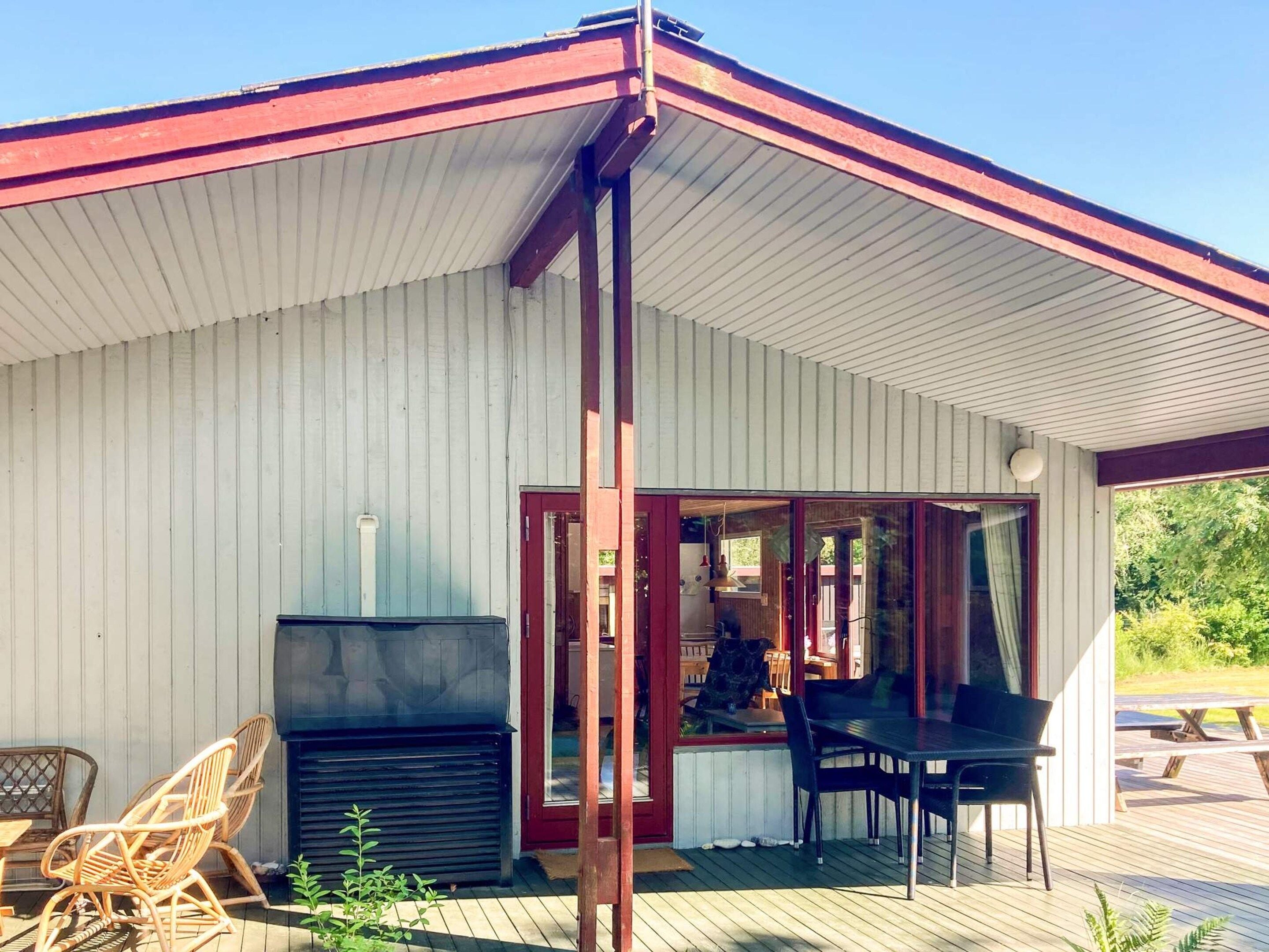 A covered outdoor area with a grill, seating, and a view of the surrounding landscape.