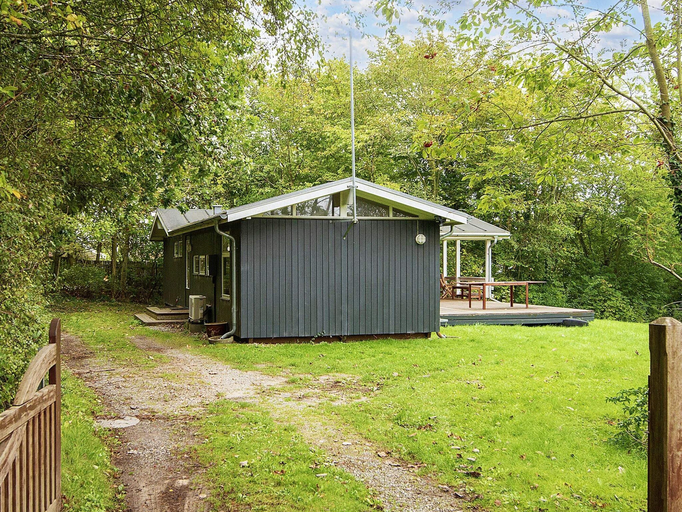 A small, single-story building with a porch and a covered outdoor seating area.