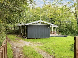 A small, single-story building with a porch and a covered outdoor seating area.