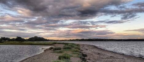 Een pad langs de rivier met grasvelden en uitzicht op het water.