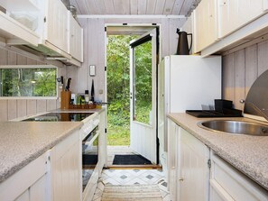 A compact kitchen with a view to the outdoors, a sink, and a door leading outside. - 8 Person Holiday Home in Ronde (Ronde)