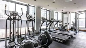 Un gimnasio con cintas de correr, elípticas y bicicletas estáticas.