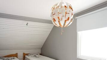 A room with two wooden bunk beds, a white radiator, and a large window providing natural light.