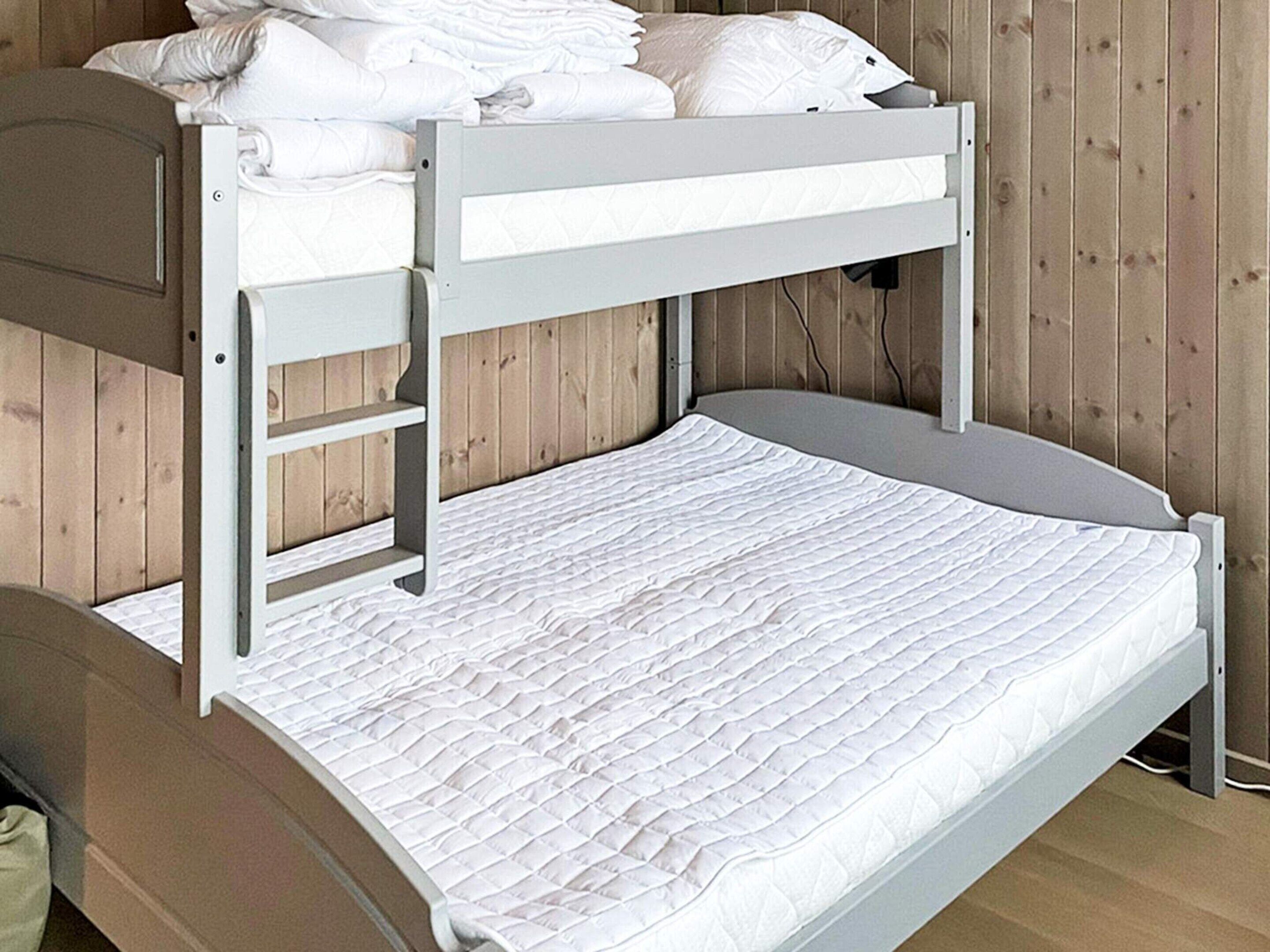 A bunk bed with a lower bunk and a mattress on the floor.