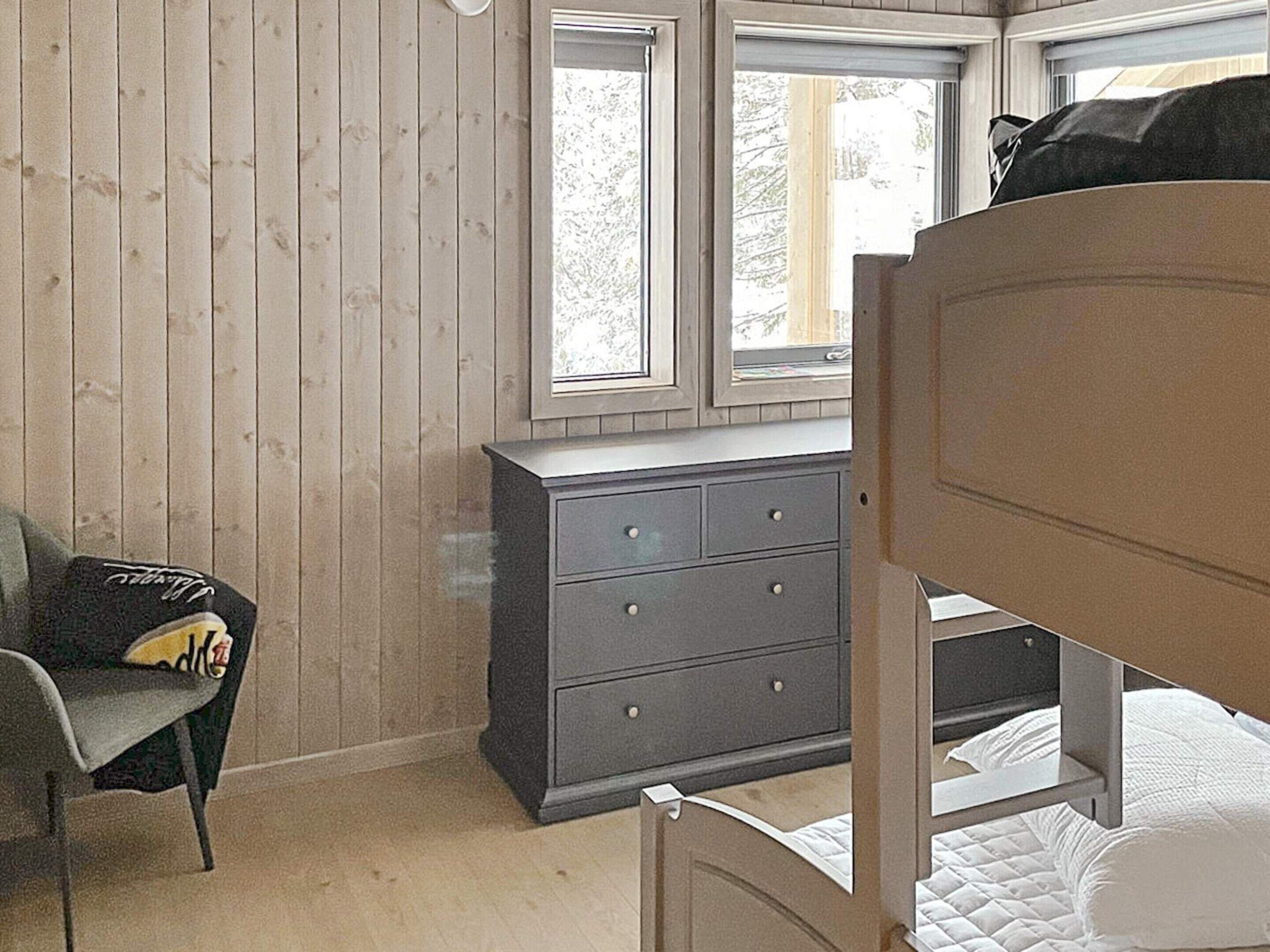 Quarto com beliche, penteadeira e uma cadeira.