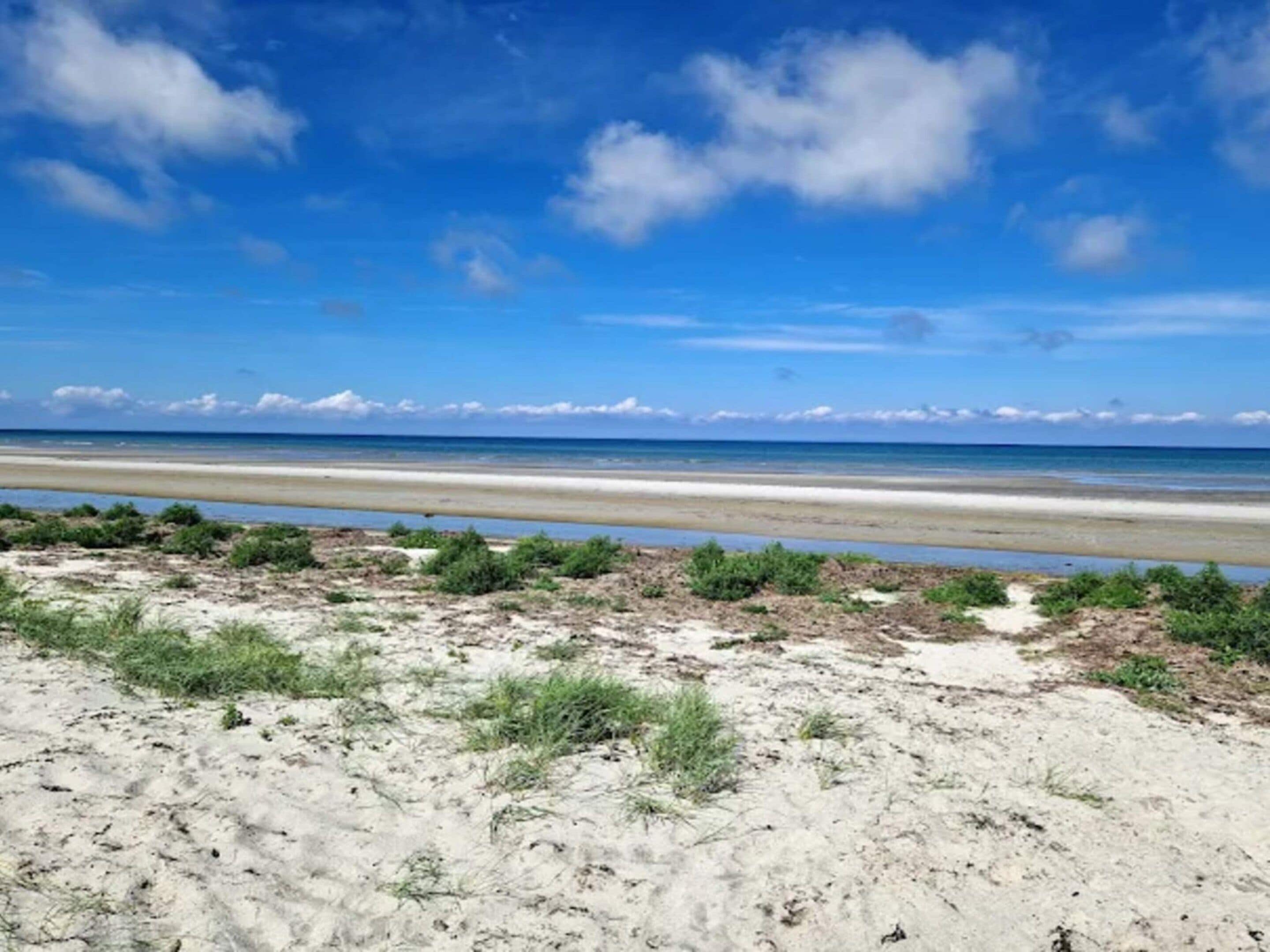 A beach with a clear sky and a sandy shore.