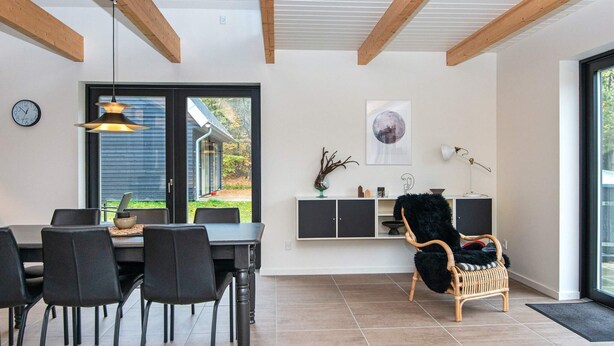 A modern dining area with a table, chairs, and a view of the outdoors through a glass door. - 6 Person Holiday Home in Hovborg (Hovborg)