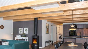 A modern living space with a fireplace, a dining area, and a kitchen. - 6 Person Holiday Home in Hovborg (Hovborg)