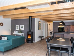 Un espacio habitable moderno con chimenea, comedor y cocina.