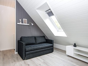 A modern loft bedroom with a sloped ceiling, a built-in bench, and a skylight. - 6 Person Holiday Home in Hovborg (Hovborg)
