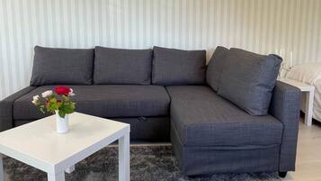 A grey sectional sofa with a white coffee table in front.