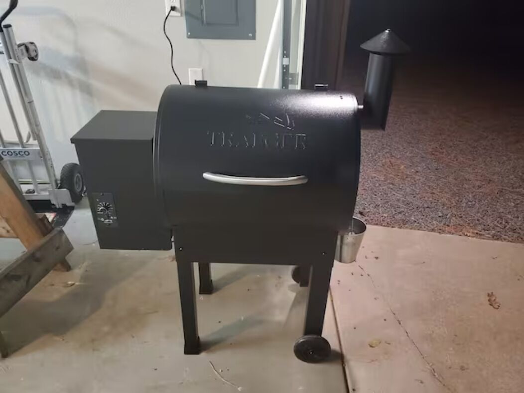 A black grill with the brand name "TRAXITR" on a stand.
