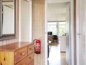 A wooden dresser with drawers, a mirror, and a fire extinguisher mounted on the wall. - 7 Person Holiday Home in Holbaek (Holbaek)