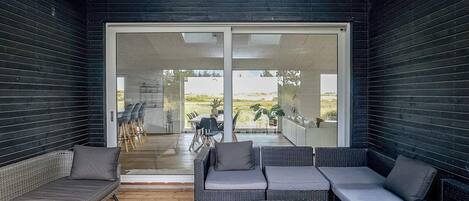 A modern outdoor living space with a sofa, chairs, and a coffee table.