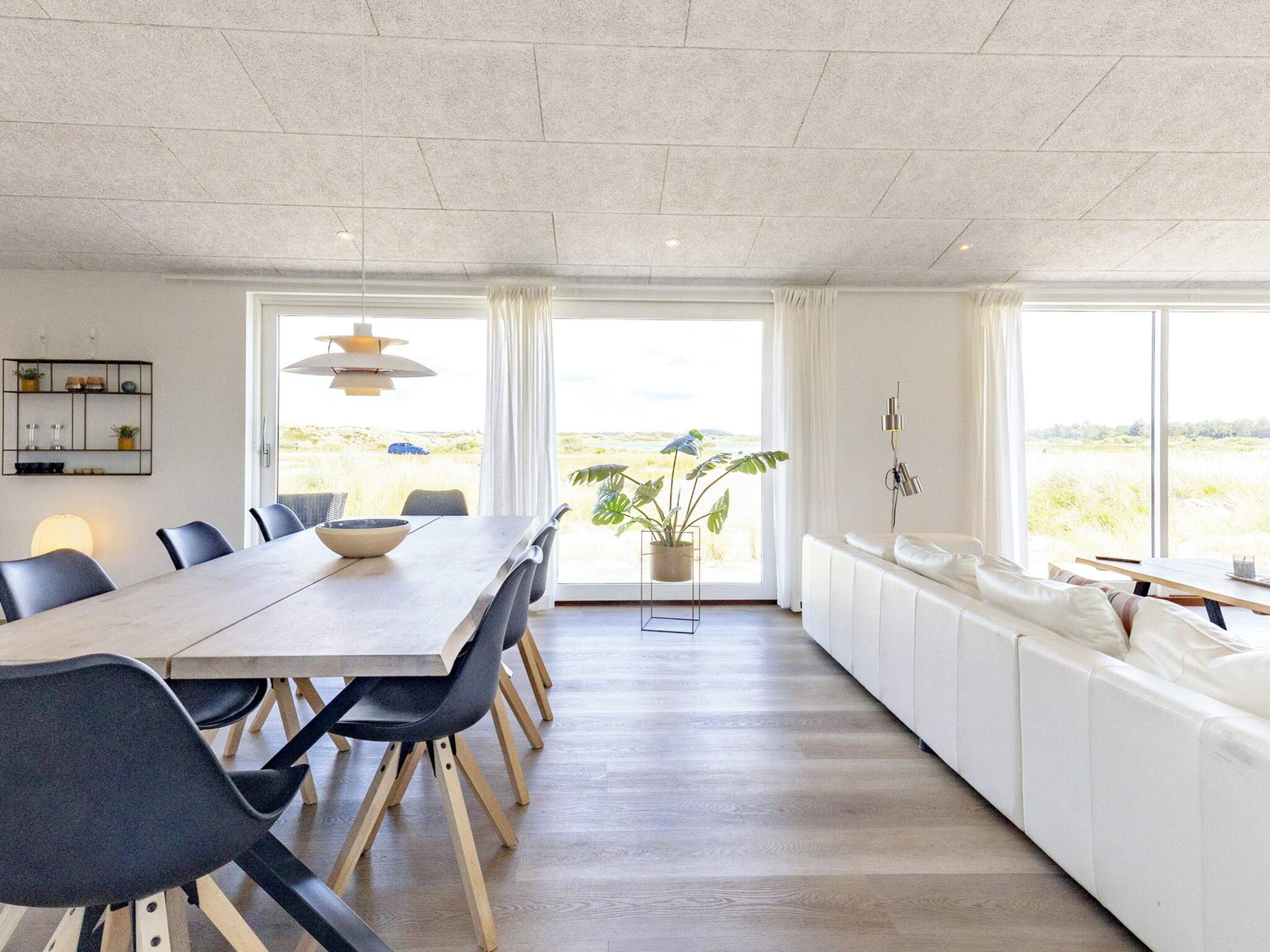 Una cocina moderna con comedor, ventanas amplias y vistas al exterior.
