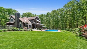A two-story house with a large backyard, a swimming pool, and a wooden deck. - Southampton Family Summer (Southampton)