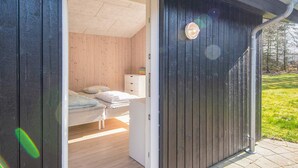 Una habitació amb un llit, una tauleta de nit i un prestatge blanc.